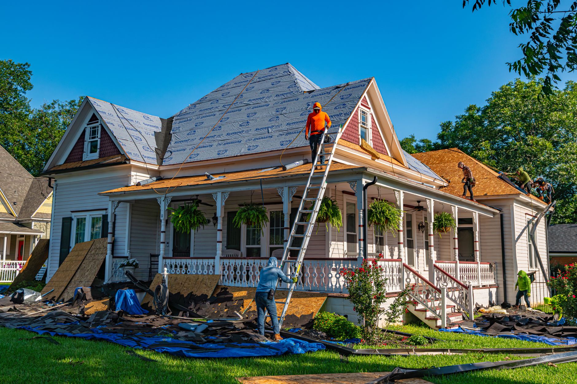 Roofing crew performing a tear-off on a residential home